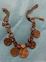 Front view of vintage Pilgrim copper necklace with five round enamel pendants and multicolored rhinestones on chain