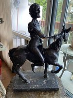 Front and left side view of the Don Quixote chalkware statue showing arm and general wear.