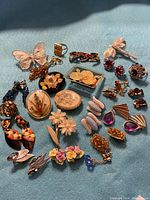 Full view of 30 vintage jewellery pieces including brooches, rings, earrings in varied styles and colors.
