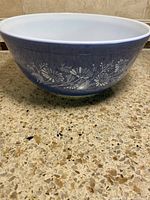 Side profile showing blue exterior with white floral decoration and white interior