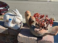 Photo showing white rabbit planter pot and two bird planter pots with succulents outside on a brick surface