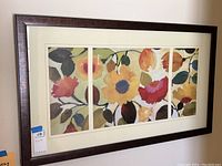 Framed floral print showing the full artwork with four vertical sections within a dark brown wood frame and light mat.