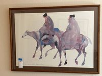 Full view of the framed artwork showing two Native American figures riding horses in muted watercolor style.