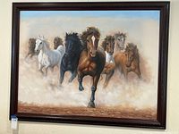 Frontal view of framed 36x48 inch oil painting of six running horses in a dusty landscape.