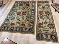 Photo of both rugs side by side showing size difference, floral patterns, and color scheme on light wood flooring.