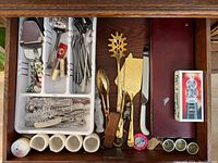 Top view of first drawer showing mixed utensils, egg cups, porcelain spoon, crystal stirrers