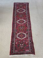 Full-length view of red geometric runner on beige carpet
