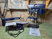 Both Mastercraft tools on workbench with manuals