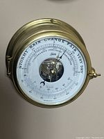 Front view of the brass compensated precision barometer by Schatz showing the dial with barometric pressure and temperature.