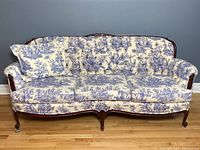 Full front view of the Victorian sofa showing fabric upholstery, seat cushions, and wooden base with carved details.