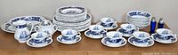 Full lot arranged on wooden surface showing all plates, cups, bowls, platters, serveware and shakers