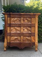 Front view of dresser showing three carved drawers with bird panels