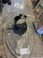 Full view of the oval glass top showing the disassembled table placed on carpet.