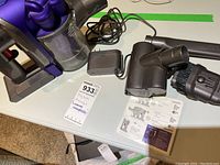 Full view showing vacuum body, motorized brush, small brush tool, wand, charger, and product tag