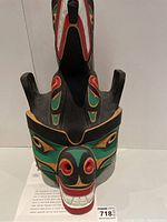 Front view of painted mask showing stylized bear face and upper wolf figure