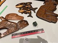 Overview of three wood carvings and small jade polar bear on table