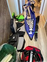Overview of deflated Aquaglide kayak with seats, lifejackets, paddles, pump and bag arranged on floor