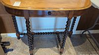 Full view of vintage wood side table showing barley twist legs, drawer, and top.