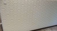 Close-up of white geometric-patterned quilted top cover