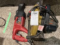 Photo showing the Skil circular saw and Skil reciprocating saw with power cords coiled, placed on carpet.