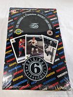 Front view of sealed Original 6 Hockey Cards wax box featuring vintage hockey card images and NHL city names pattern.