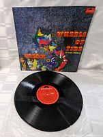 Vinyl record and album cover spread out showing front artwork and record label.