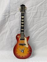 Full view of the guitar style clock showing the entire body, neck, and headstock with the clock face on the guitar body.