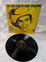 Front cover and vinyl record of 'The Very Best of Hank Williams' showing cover art and condition.