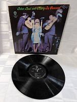 Front cover of Peter, Paul and Mary In Concert album showing the three performers on stage.