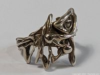 Close-up front view of sterling silver abstract artisan ring showing the intricate twisted and looping design.