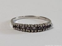 Front angled view of the sterling silver ring showing amethyst stones set along the band.