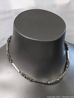 Front view of the 16-inch sterling silver gothic necklace chain displayed on a black neck mannequin, showing the even distribution of twisted knot and flat bar segments.