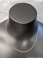 Necklace displayed on black bust showing overall length and thickness.