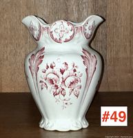 Front view of antique toothbrush holder showing floral and ornamental reddish-brown transfer ware decoration on white ceramic.