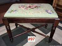 Front view showing needlepoint upholstered top, turned legs and X-stretcher base