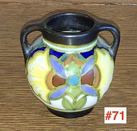 Front view of the small Gouda Holland art pottery vase showing floral design and double handles.