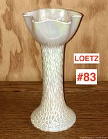 Full view of tall Loetz iridescent vase showing scalloped rim, lava texture, and wide base.