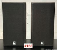 Front view of both speakers with black fabric covers on.