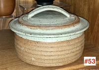 Front angled view of the covered server showing lid with handle and body with ribbed texture and two-tone glaze.