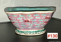 Side profile of the vintage Asian pottery bowl showing pink exterior with turquoise cloud motifs and green base pattern.