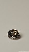 Close-up image of oval light champagne zircon gemstone showing facets and color