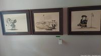 Three framed golf-themed prints hung on a wall titled Tee Off, The Green, and 18th Hole.