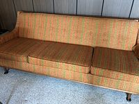 Front and side overview of the sofa showing full frame, three cushions, tapered legs