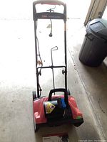 Front view of the Toro Power Curve 1800 snow thrower showing the red body, black chute, and wheels on each side.