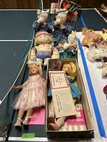 Photo showing two Elf on a Shelf style dolls, Tennis Boo Doo doll, two crafted cats, Toni doll in pink dress and Toni doll in parts with Play Wave instructions