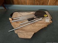 Photo of Woodstock wind chimes laid out on crumpled brown paper with original box underneath showing partial Woodstock Chimes logo.