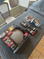 Photo of Star Wars Death Star Electronic Lab boxed game, three Star Wars action figure toys in boxes, and collectible Pepsi cup with Star Wars character on lid.
