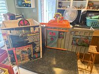 G.I. Joe Adventure Team Headquarters playset displayed alongside original box on a table. Box shows full color graphics and branding.