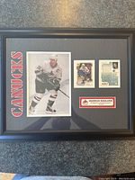 Framed tribute showing full layout including large photo, two hockey cards, plaque with name and tribute text