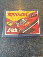 Top view of the blue and yellow vintage Matchbox carry case with colorful printed cover showing stylized cars